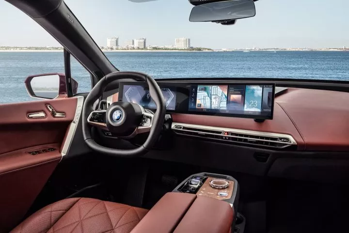 Vista delantera de la cabina del BMW iX con volante y pantallas digitales