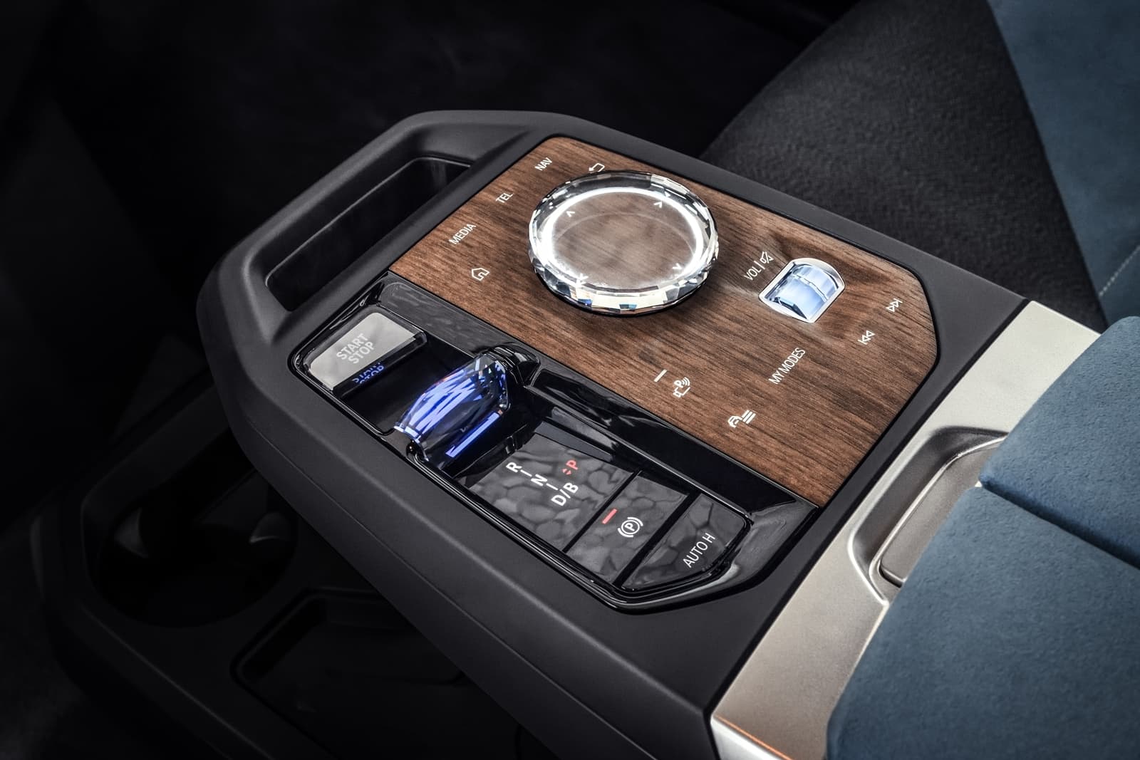 Consola central del BMW iX con acabados de madera y controles táctiles.