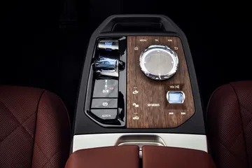 Vista superior de la consola central del BMW iX con acabados en madera y cuero.