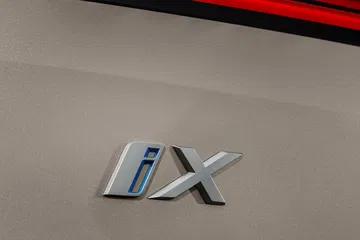 Primer plano del emblema del BMW iX, detalle distintivo.
