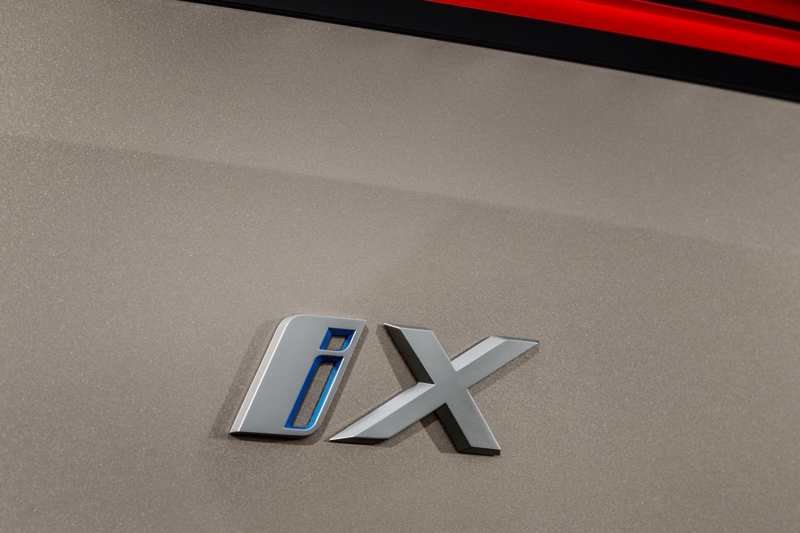 Primer plano del emblema del BMW iX, detalle distintivo.
