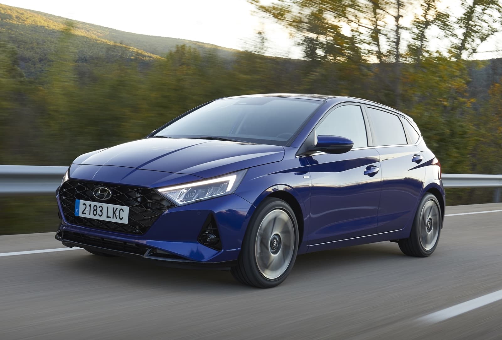 Vista lateral dinámica del Hyundai i20 en movimiento, color azul.