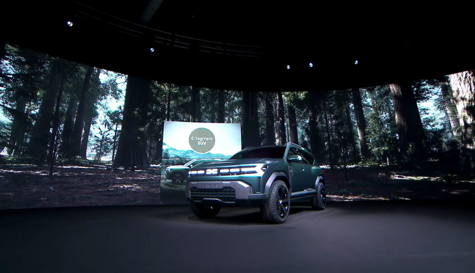 Vista frontal del Dacia Bigster en su presentación, iluminación tenue y fondo de bosque.