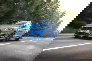 Vista dinámica del Ford Fiesta en carretera, destacando su diseño frontal y lateral.
