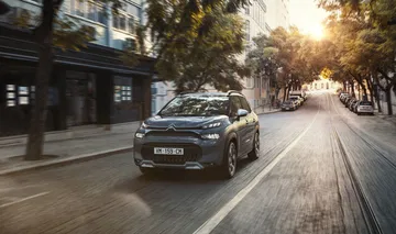 Imagen dinámica del Citroën C3 Aircross por la ciudad al atardecer.