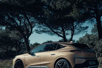 Vista lateral del DS 4 en un entorno natural, destacando su diseño y líneas elegantes.