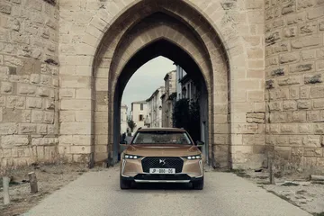 El DS 4 muestra su imponente frontal ante un arco histórico, destacando su diseño elegante.