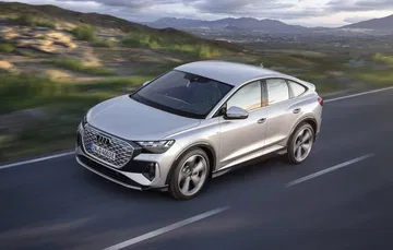Vista dinámica del Audi Q4 e-tron mostrando su línea lateral y frontal elegantes