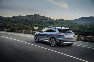 Vista dinámica de la trasera y lateral del Audi Q4 e-tron en carretera.