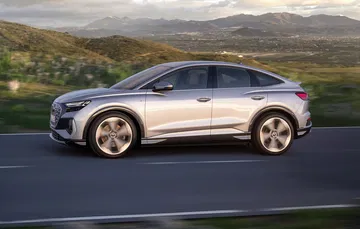 Vista lateral del Audi Q4 e-tron destacando su línea dinámica y llantas.
