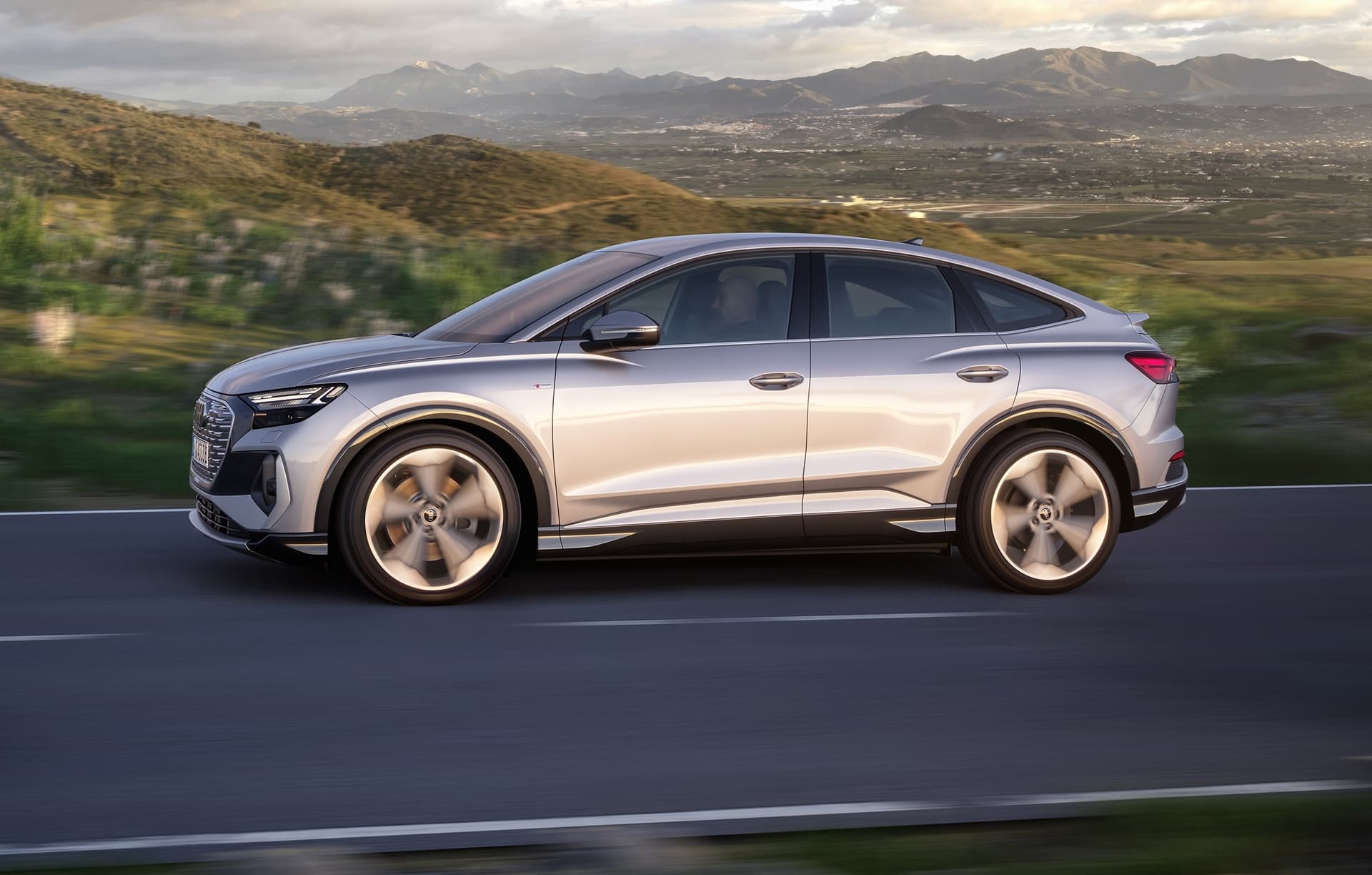 Vista lateral del Audi Q4 e-tron destacando su línea dinámica y llantas.
