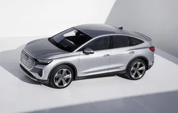 Vista lateral del Audi Q4 e-tron mostrando su elegante línea y llantas.
