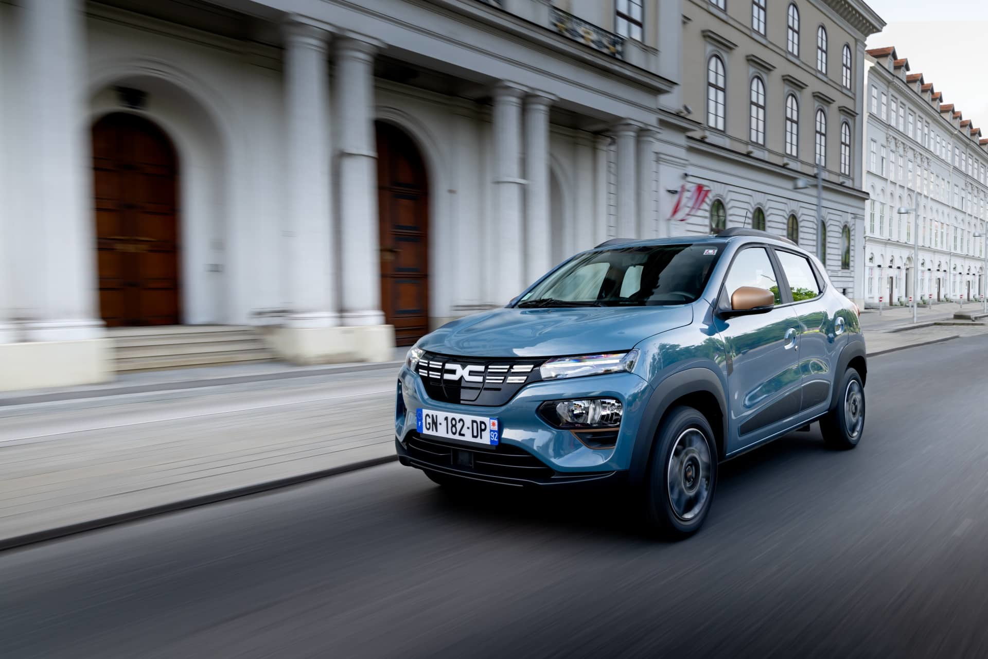 Vista dinámica del Dacia Spring en ambiente urbano mostrando su frontal y perfil.