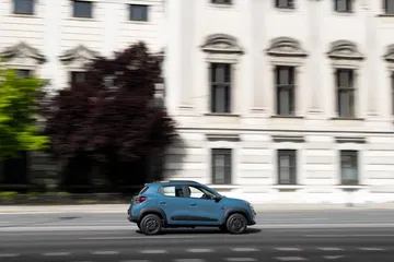 El Dacia Spring captado en un entorno urbano, mostrando su perfil lateral.