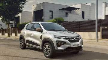 Perfil lateral del Dacia Spring en movimiento, destacando su diseño compacto.