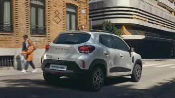 Vista trasera y lateral del Dacia Spring, destacando líneas y ópticas.