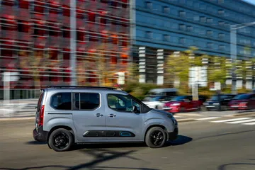 Vista lateral del Citroën Berlingo en movimiento por la ciudad.