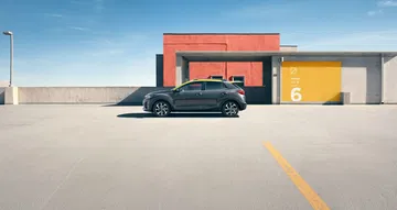 Vista lateral del Kia Stonic aparcado, diseño actual y líneas aerodinámicas.