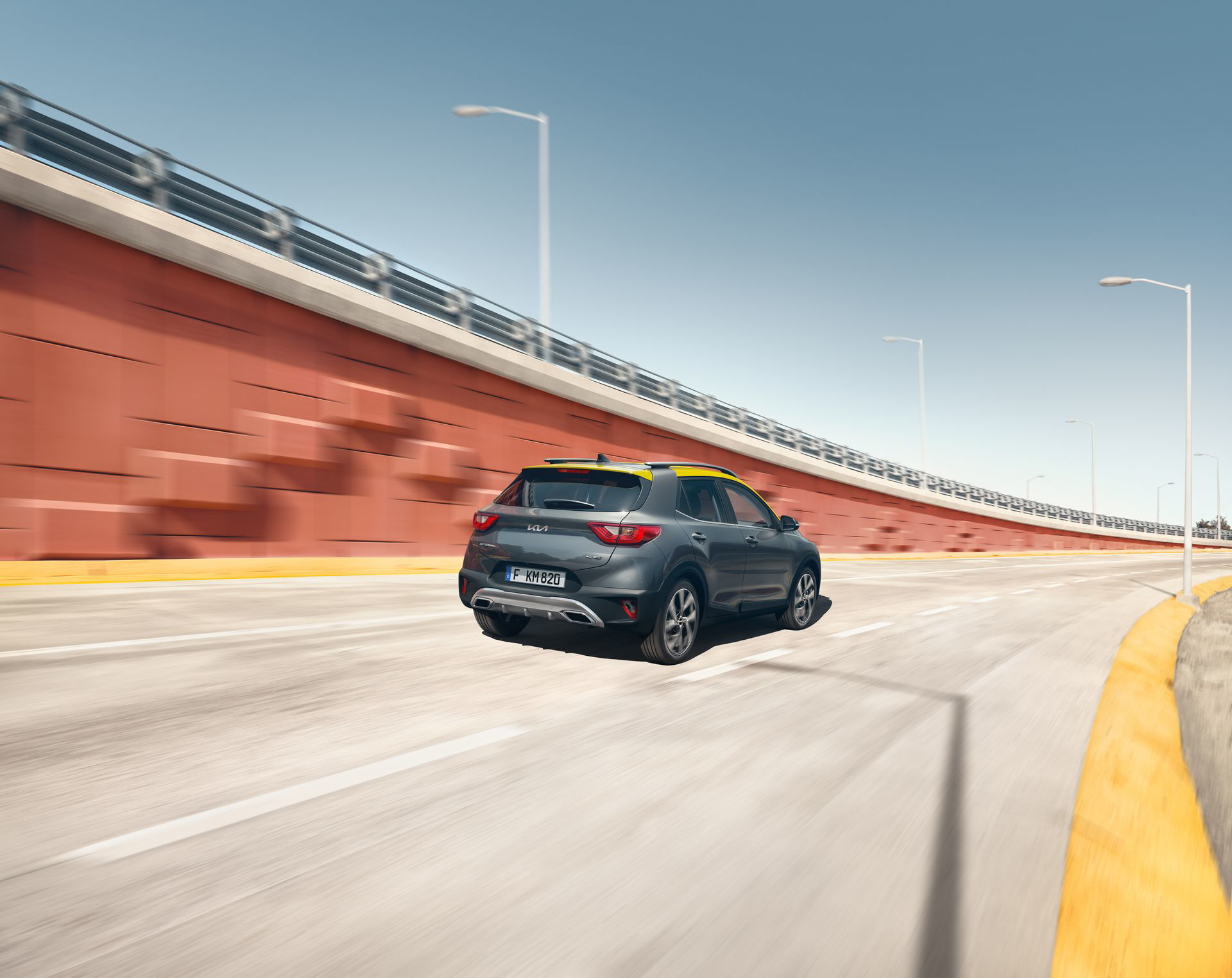 Vista dinámica de la parte trasera y lateral del Kia Stonic en movimiento.