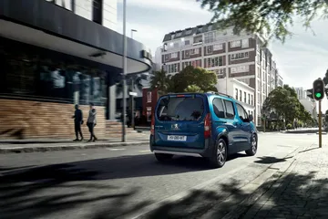 Vista lateral y trasera del Peugeot e-Rifter en entorno urbano.