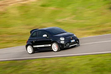 Abarth 695 captado en acción, destacando su perfil lateral y dinamismo en pista.