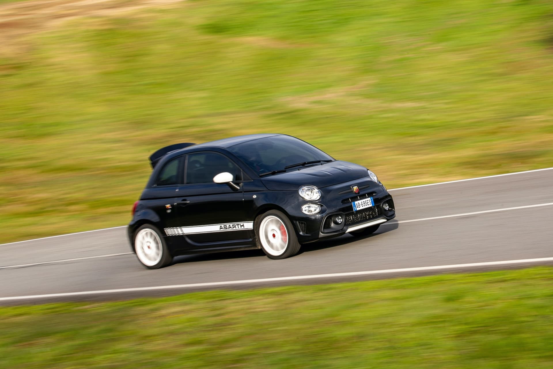 Abarth 695 captado en acción, destacando su perfil lateral y dinamismo en pista.