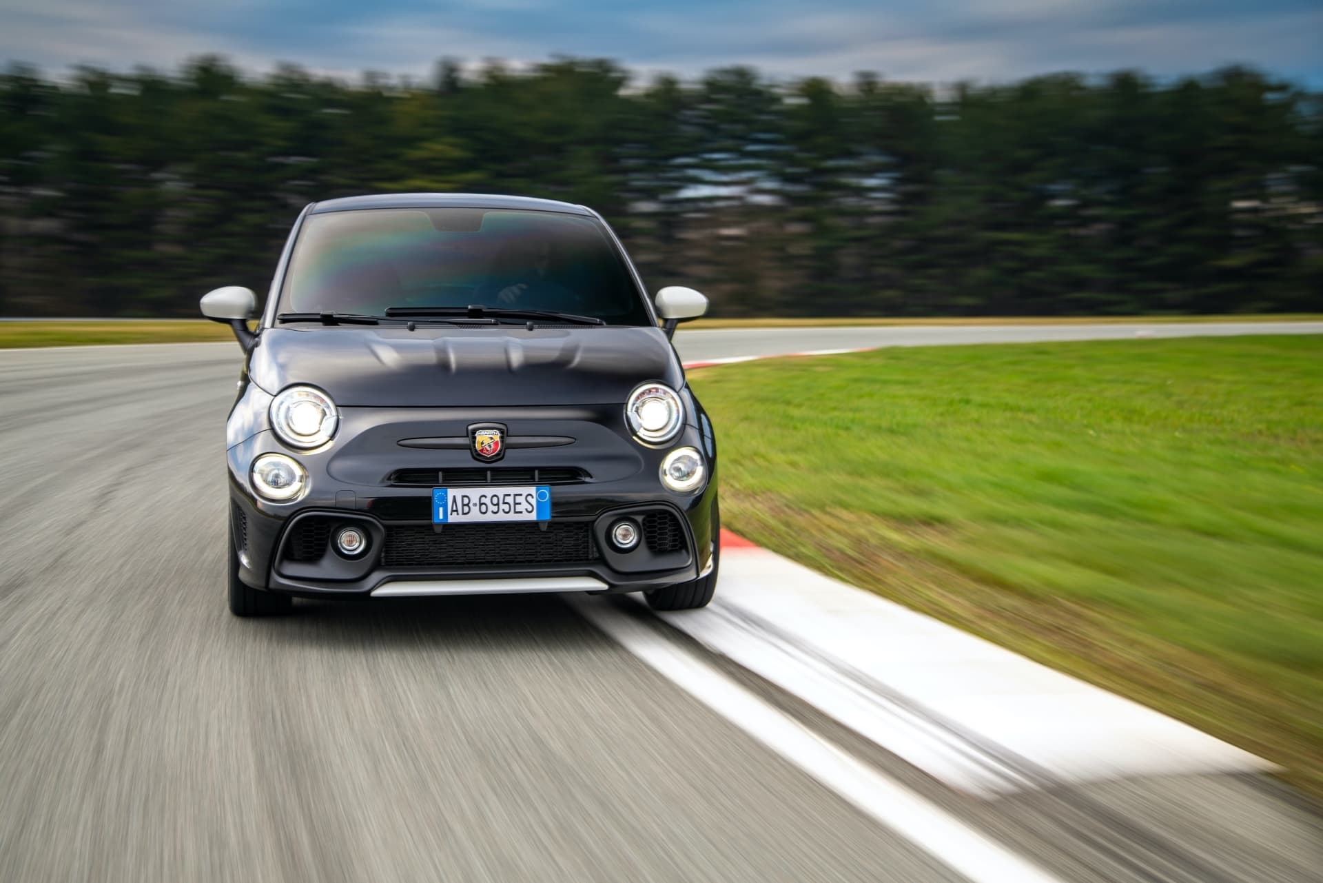 Vista dinámica del Abarth 695 en acción, destacando su frontal agresivo.