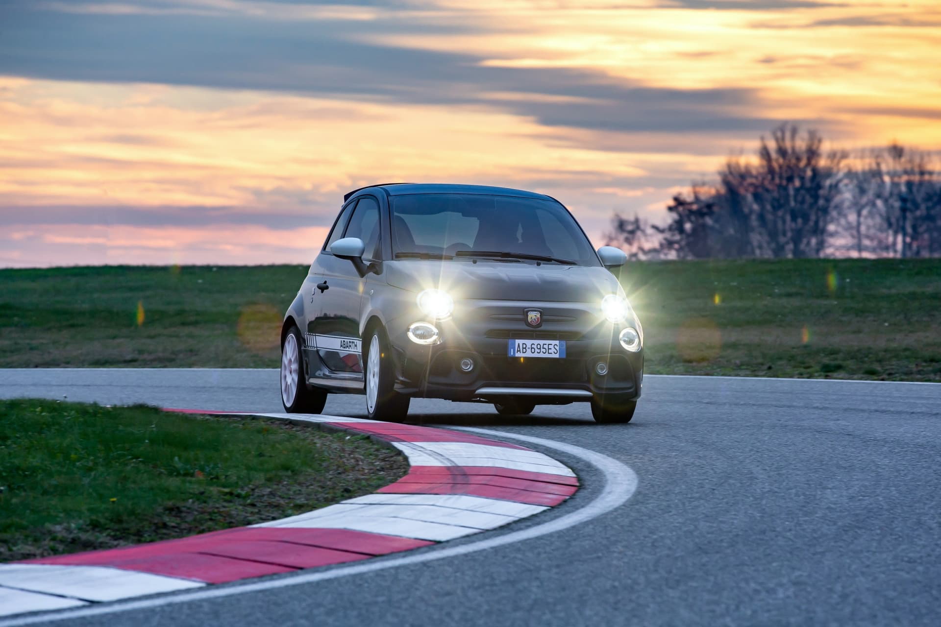 Vista dinámica del Abarth 695 en acción, resaltando su frontal agresivo y perfil deportivo.