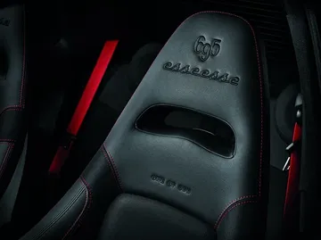 Vista cercana del asiento deportivo del Abarth 695, destacando el logotipo grabado.