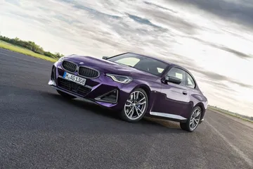 BMW Serie 2 mostrando su perfil lateral en una curva cerrada, realzando su diseño deportivo.