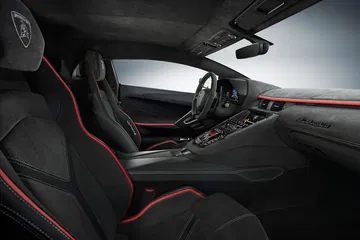 Vista lateral del interior de un Lamborghini Aventador, destacando sus asientos deportivos y acabados premium.