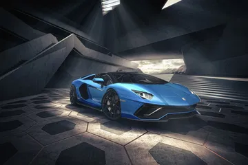 Vista dinámica del Lamborghini Aventador en azul, resaltando su agresiva delantera y perfil.