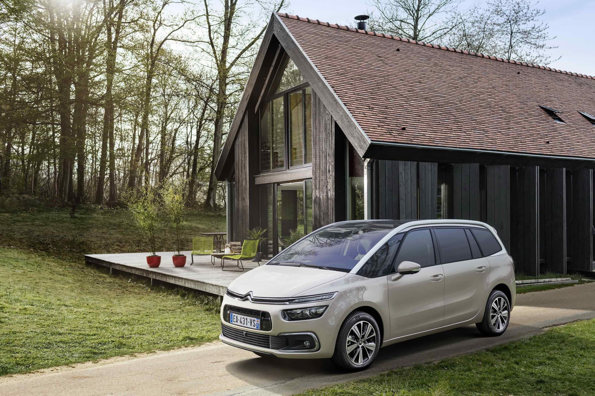 Vista delantera y lateral del Citroën Grand C4 SpaceTourer aparcado frente a una casa