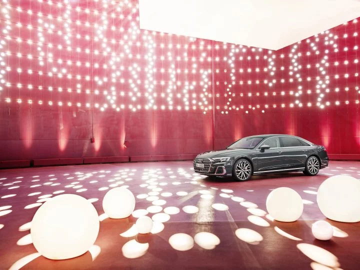 Audi A8 en un ambiente iluminado mostrando su diseño lateral.