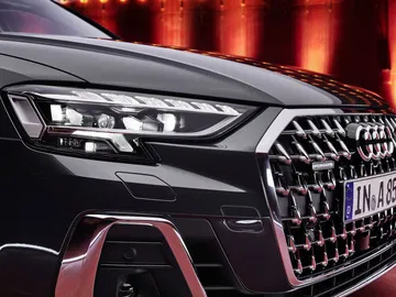 Vista cercana de la parrilla y faro delanteros del Audi A8, destacando su diseño vanguardista.