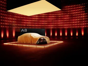 El nuevo Audi A8 se insinúa bajo la lona, prometiendo una silueta elegante y moderna.