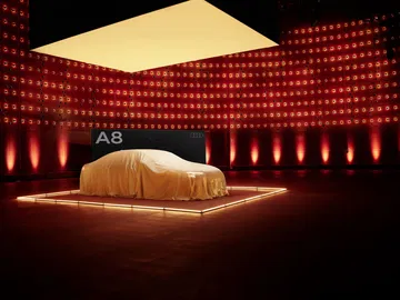 Misteriosa presentación del Audi A8 bajo una lona, promesa de elegancia y tecnología.