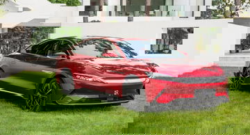 Vista lateral del BYD Han en un color rojo vibrante, destacando su diseño aerodinámico.