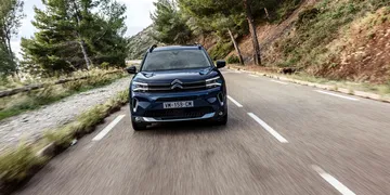 Vista frontal del Citroën C5 Aircross en movimiento por una carretera serpenteante.