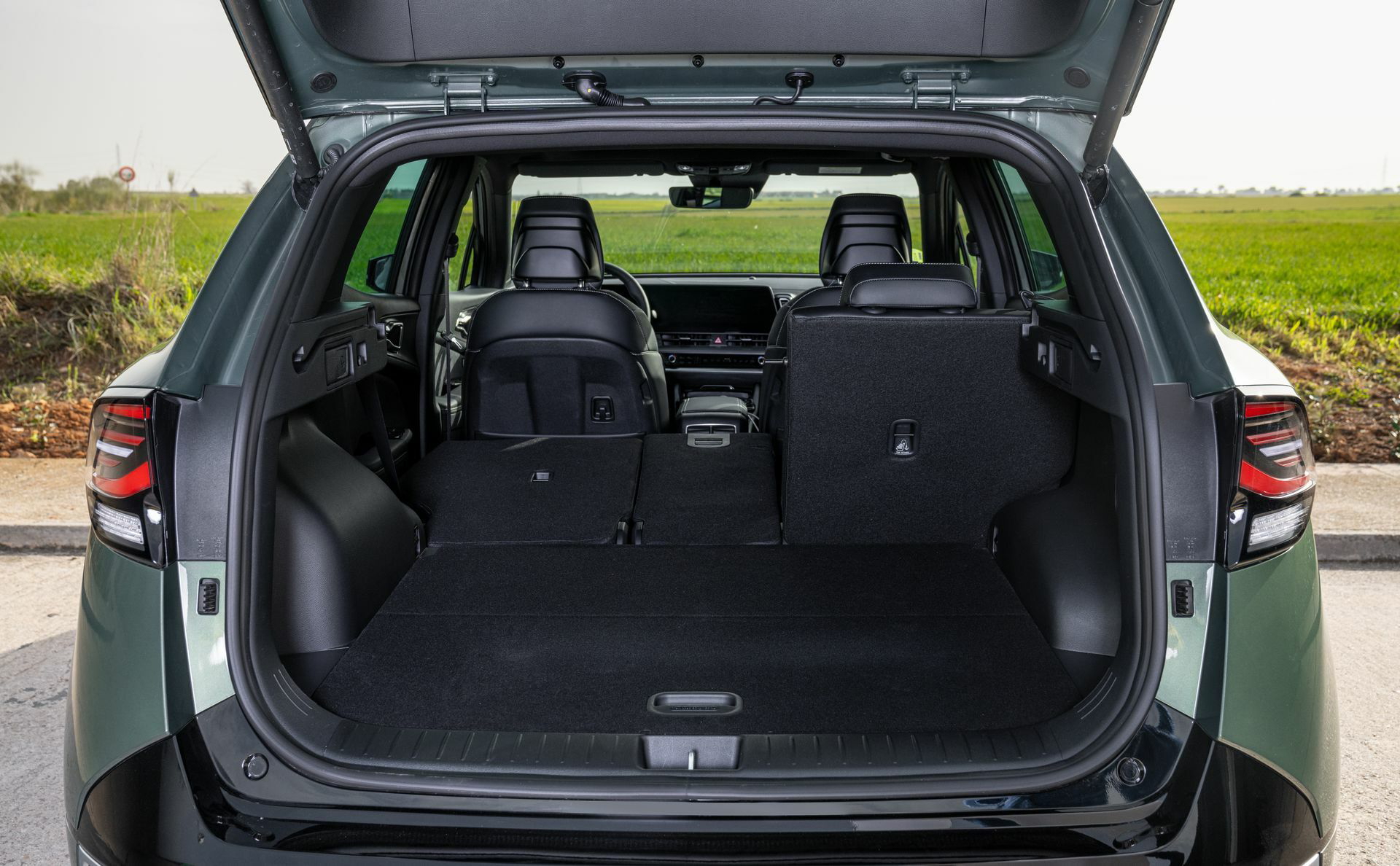 Vista trasera del Kia Sportage con el maletero abierto y asientos abatidos.