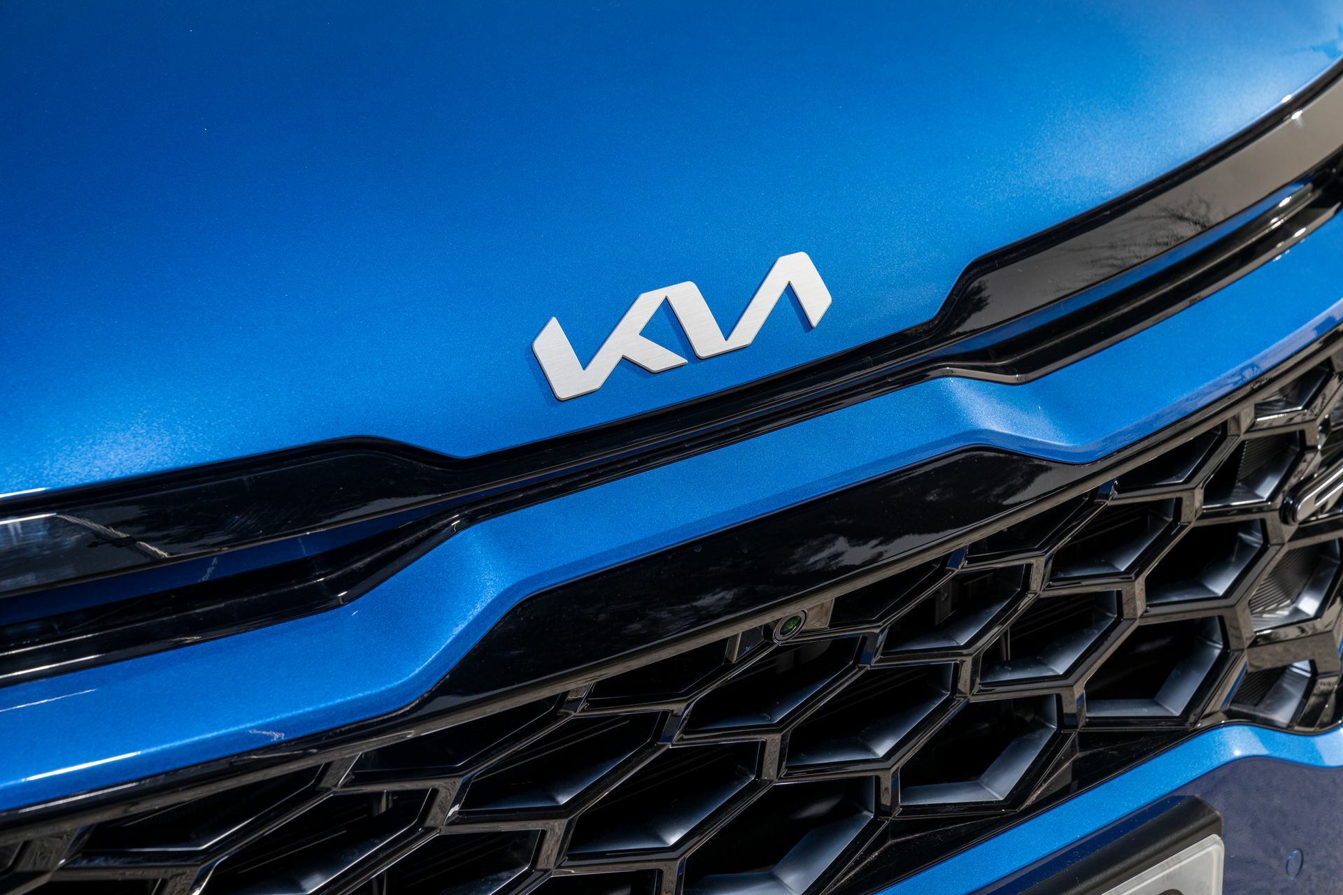 Primer plano del emblema de Kia en la parrilla del Sportage.