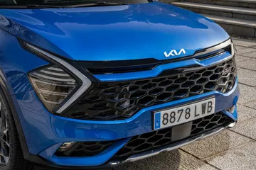Vista cercana de la parrilla y faros del Kia Sportage, destacando su diseño audaz.