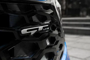 Vista cercana de la rejilla y el emblema GT Line del Kia Sportage.