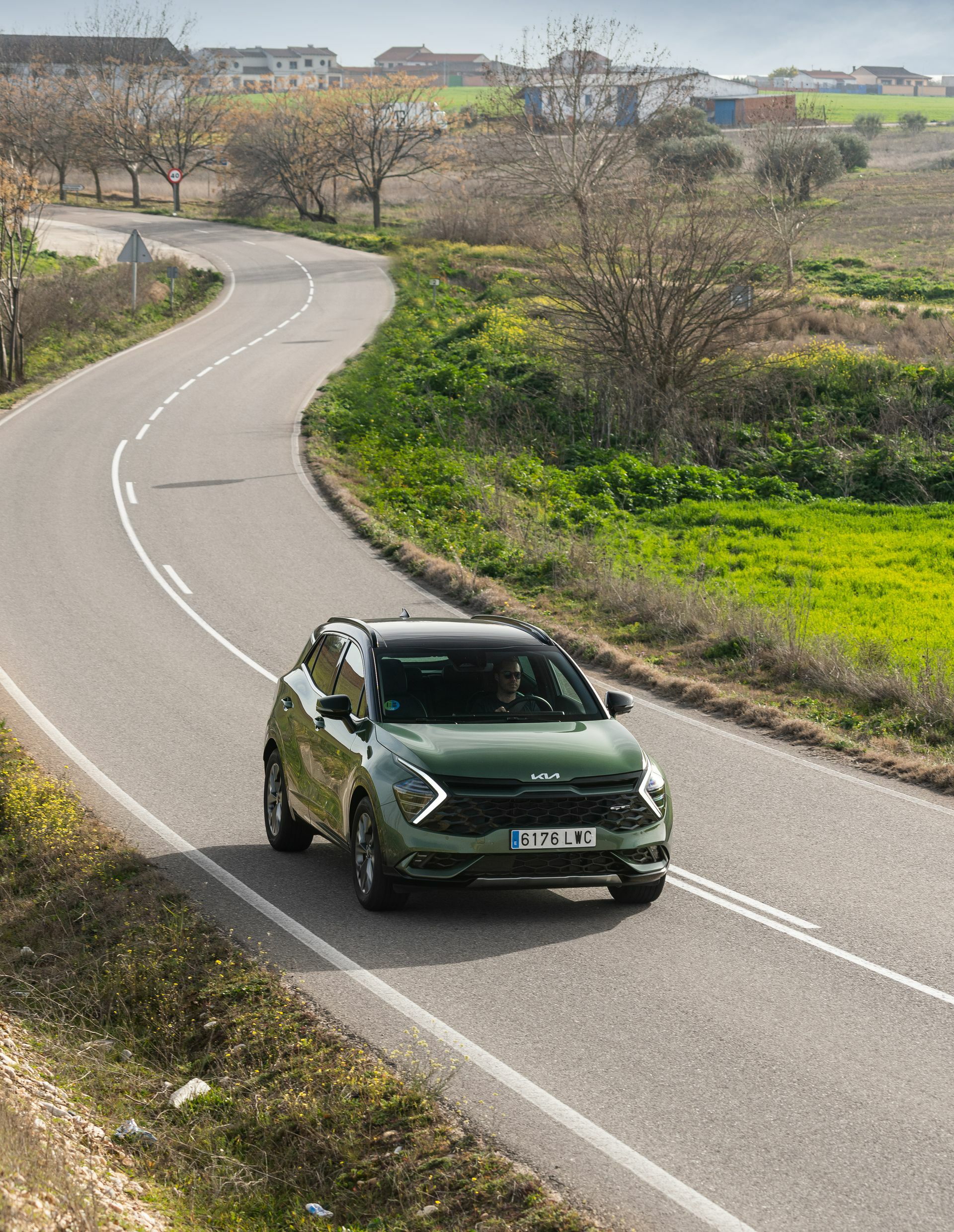 Vista dinámica del Kia Sportage en carretera, destacando su línea y diseño frontal.