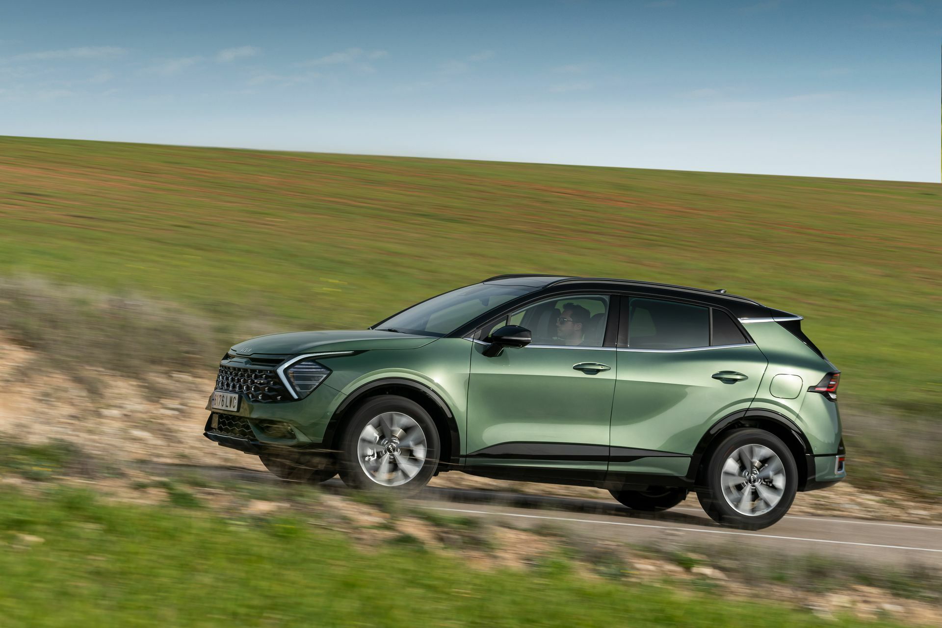 Vista lateral del Kia Sportage rodando por terreno natural