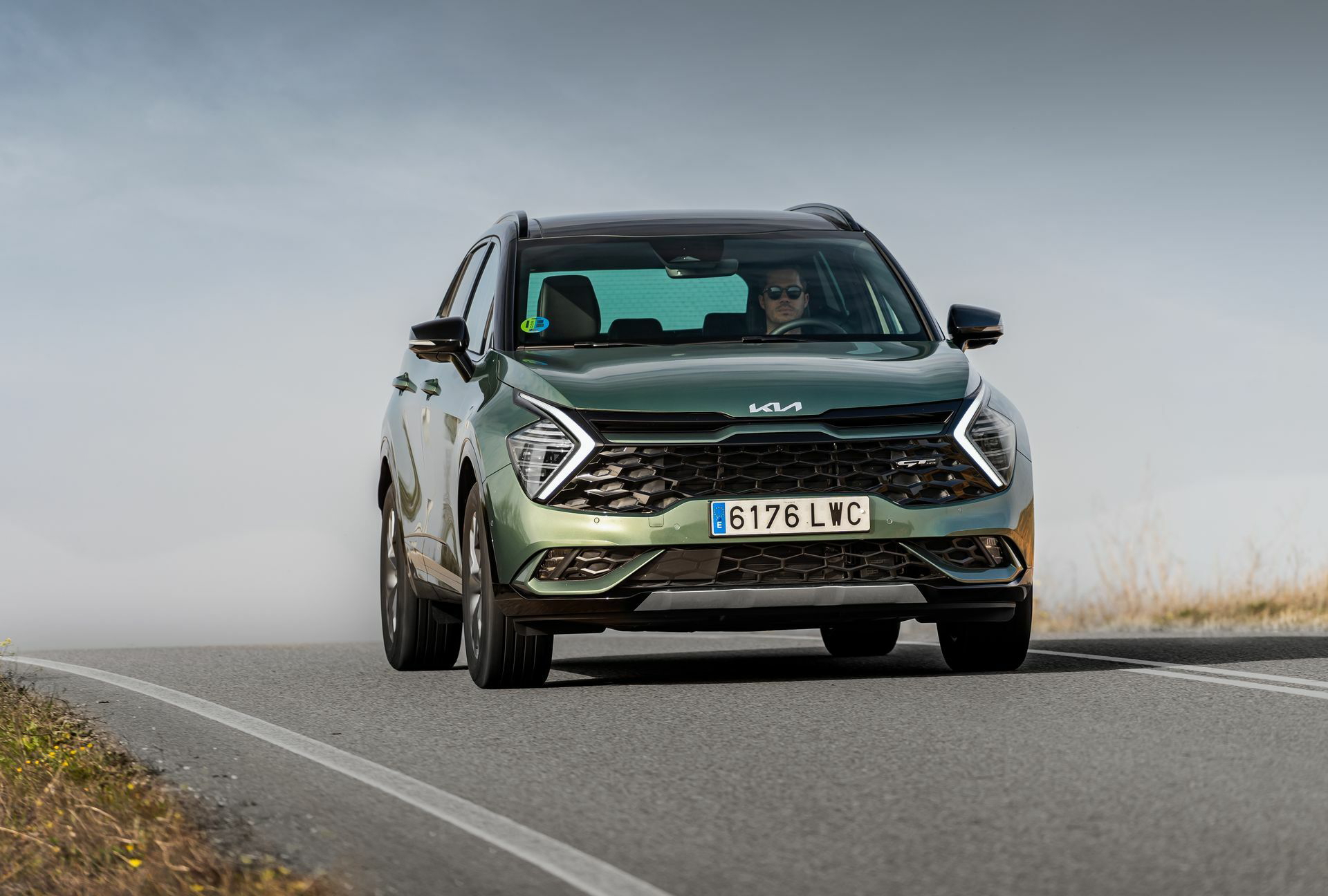 Vista frontal y lateral del Kia Sportage en movimiento.