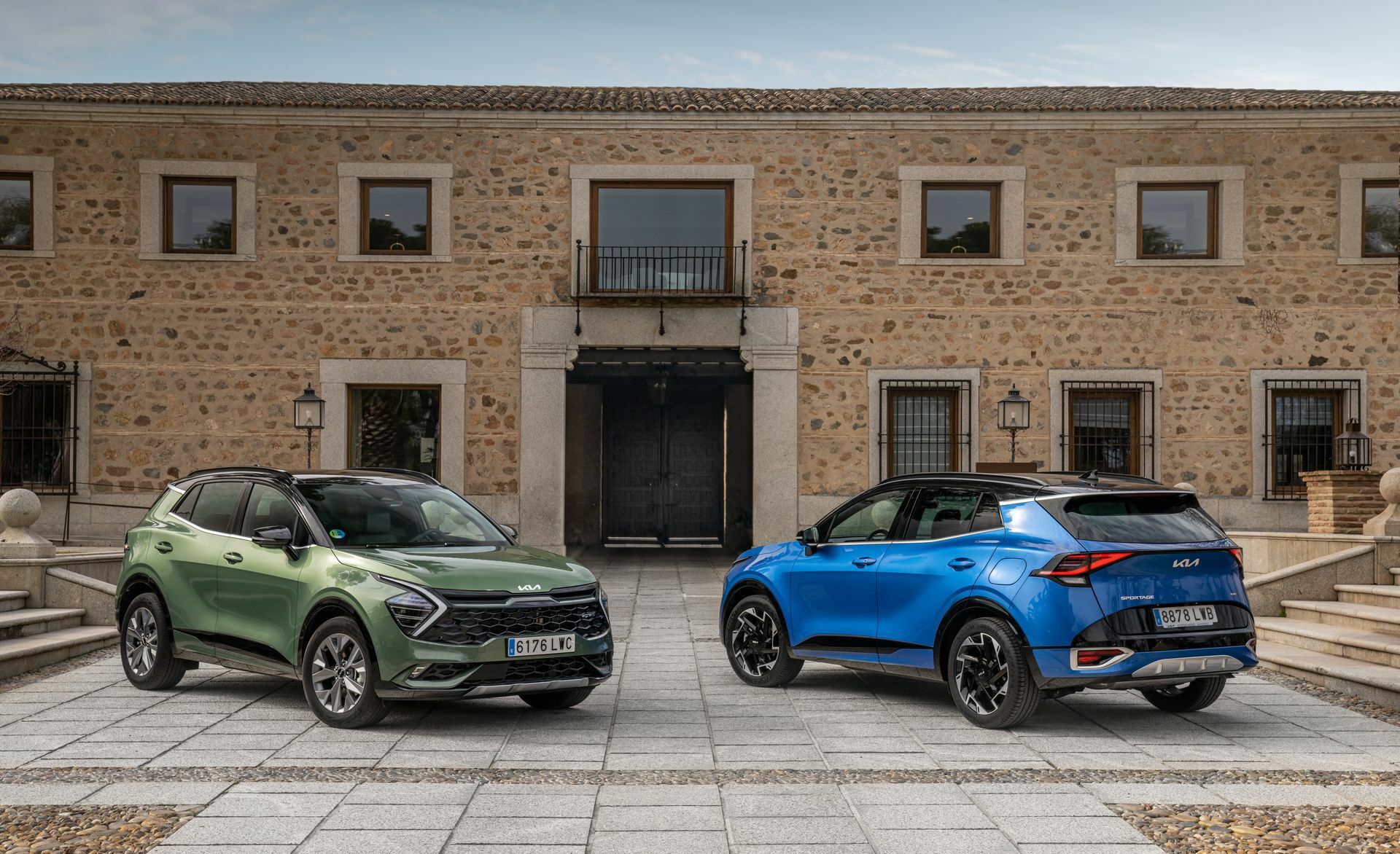Dos Kia Sportage frente a edificio histórico, destacando su diseño vanguardista.