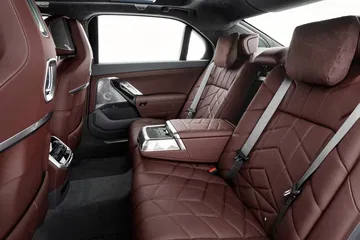 Vista lujosa de los asientos traseros con acabados premium y detalles en madera.