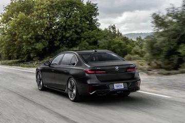 Vista dinámica del BMW Serie 7 en carretera, destacando su diseño lateral.