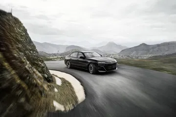 Vista dinámica del BMW Serie 7 tomando una curva en un entorno montañoso.